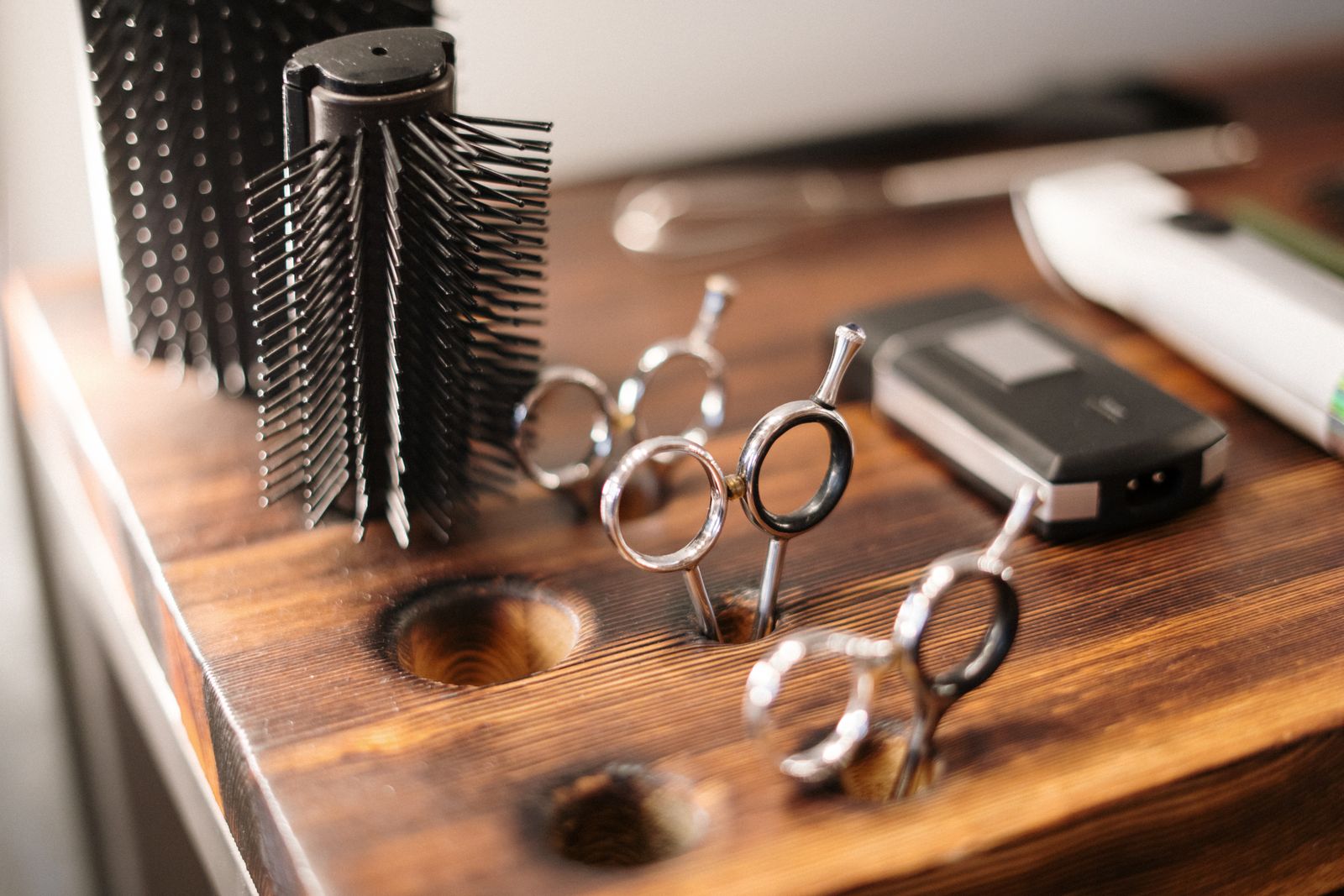 Professional hairdressing scissors and brushes on a wooden station
